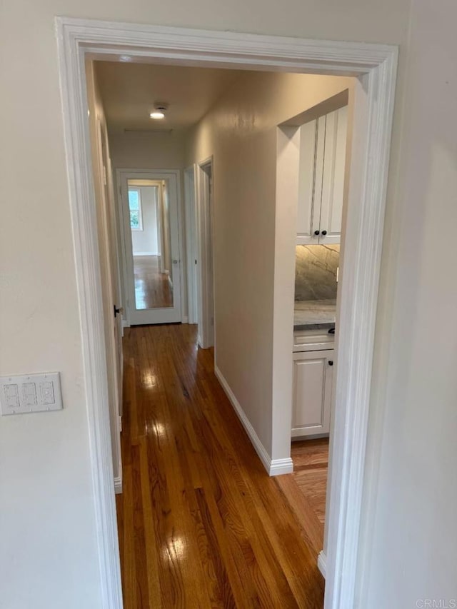 hallway with light wood-style flooring and baseboards