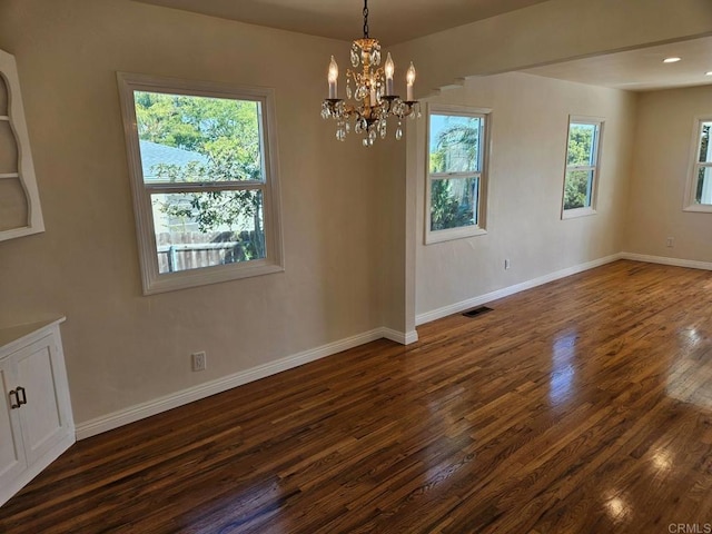 spare room featuring dark wood-style floors, visible vents, baseboards, recessed lighting, and a chandelier