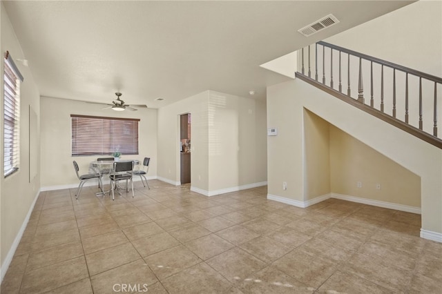 interior space featuring tile patterned flooring, baseboards, visible vents, and a ceiling fan