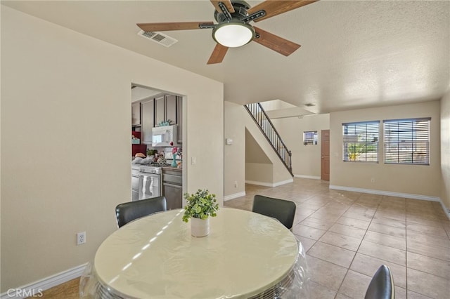 36857 42nd St E, Palmdale, CA 93552 - dining space featuring light tile patterned floors, baseboards, visible vents, stairs, and a textured ceiling
