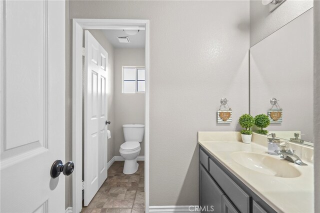 36857 42nd St E, Palmdale, CA 93552 - bathroom with visible vents, baseboards, toilet, stone finish floor, and vanity