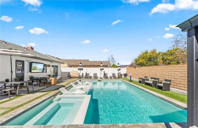 view of swimming pool featuring a patio, a fenced backyard, and a pool with connected hot tub