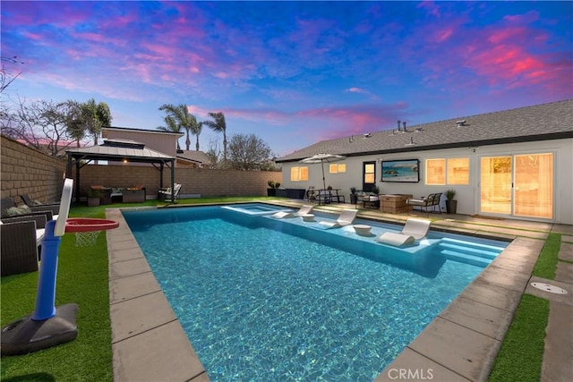 view of pool with a pool with connected hot tub, a gazebo, an outdoor hangout area, a patio area, and a fenced backyard