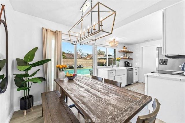 dining space with light wood-type flooring and baseboards