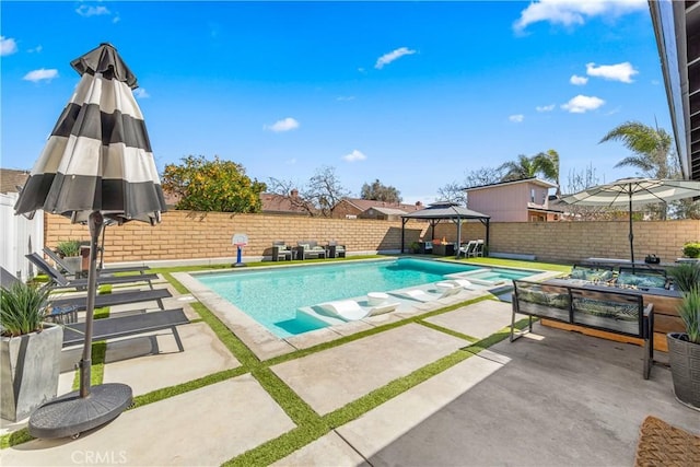 view of swimming pool with a fenced backyard, a pool with connected hot tub, a patio, and a gazebo