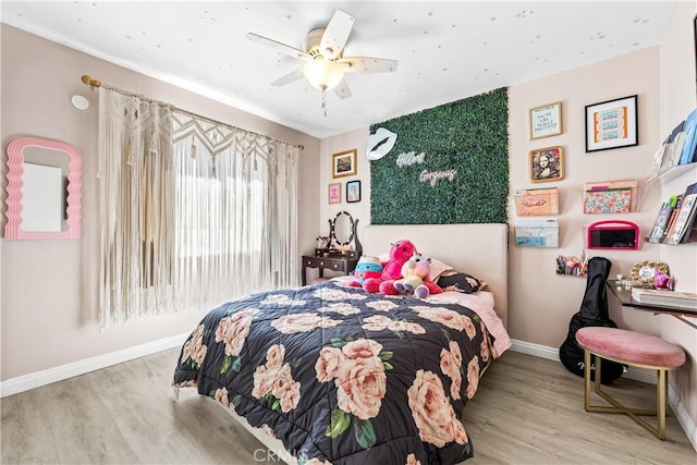 bedroom with ceiling fan, baseboards, and wood finished floors