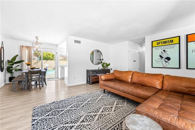 living room featuring baseboards, visible vents, and light wood-style floors