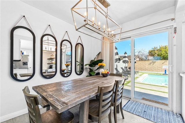 dining area with a chandelier and baseboards