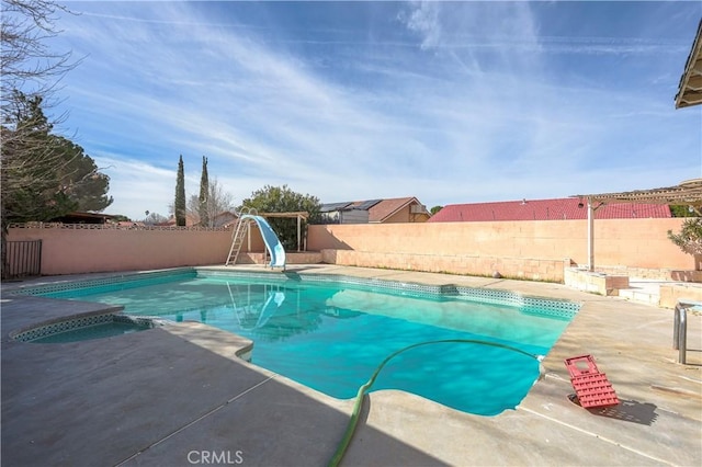 view of swimming pool with a water slide, a patio area, a fenced backyard, and a fenced in pool