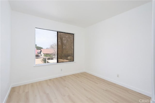 unfurnished room with light wood-type flooring and baseboards