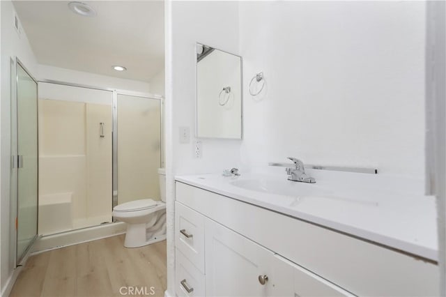 full bath with toilet, a shower stall, wood finished floors, and vanity