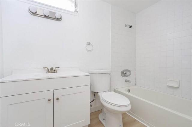 bathroom with toilet,  shower combination, wood finished floors, and vanity