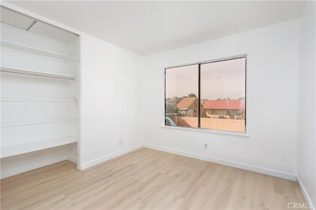 empty room with baseboards and wood finished floors