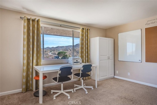 carpeted office with a mountain view and baseboards