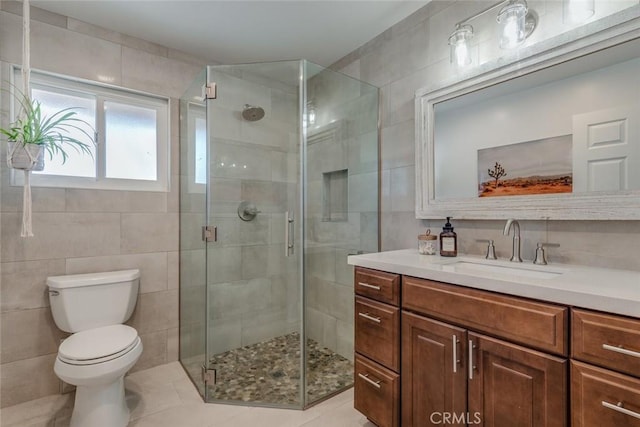 bathroom with toilet, a shower stall, and tile walls