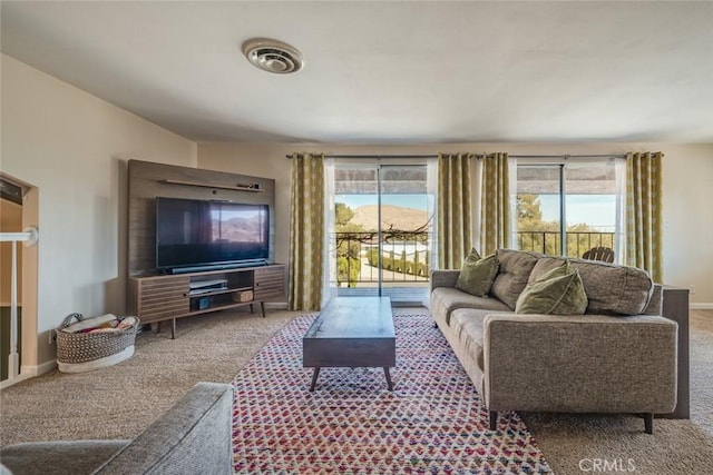 carpeted living room featuring visible vents and baseboards