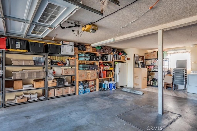 garage with washer / dryer, a garage door opener, and freestanding refrigerator