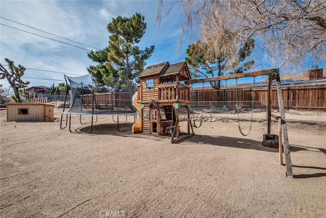 view of playground with a trampoline, an outbuilding, and a fenced backyard