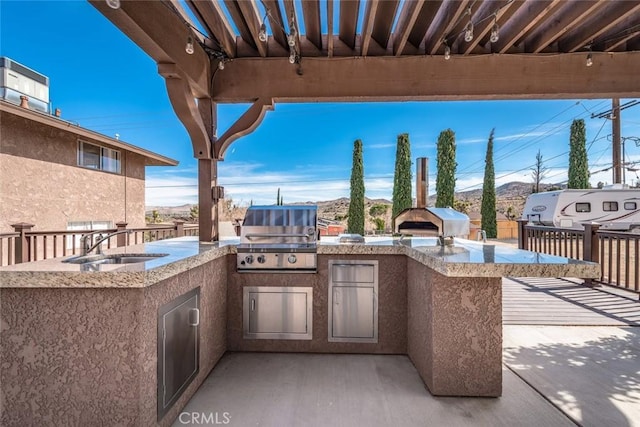 view of patio featuring a sink, exterior kitchen, and a grill