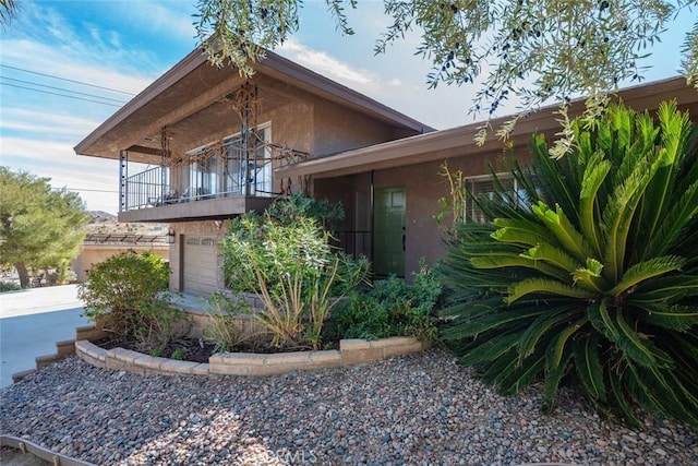 view of front of house featuring a balcony and stucco siding