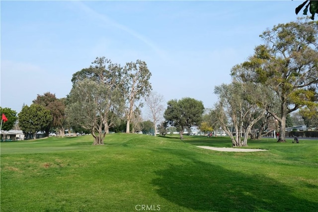 surrounding community with a yard and golf course view