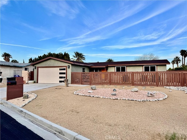 single story home featuring stucco siding, an attached garage, driveway, and fence