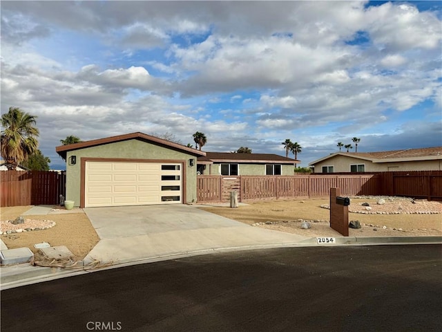 single story home with concrete driveway, a garage, a fenced front yard, and stucco siding