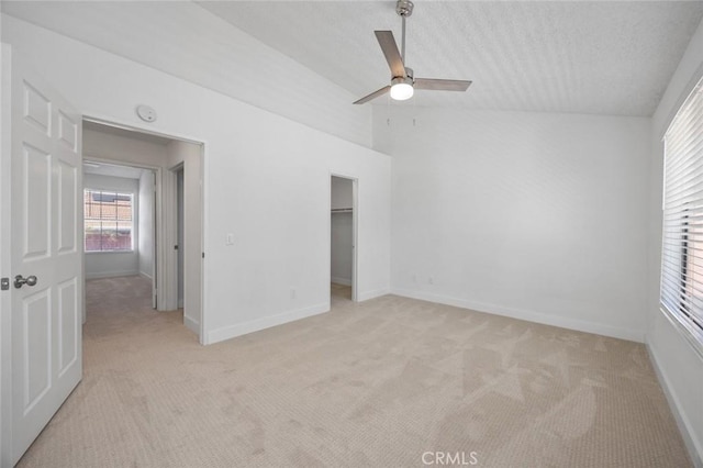 unfurnished bedroom featuring lofted ceiling, light colored carpet, and baseboards