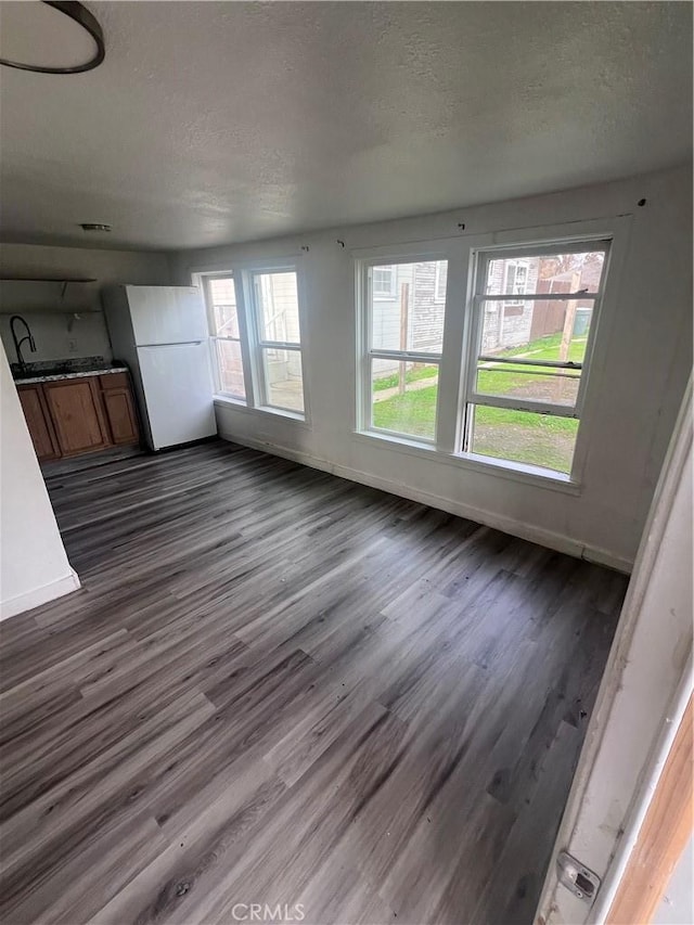 interior space featuring dark wood-style floors, baseboards, and a textured ceiling