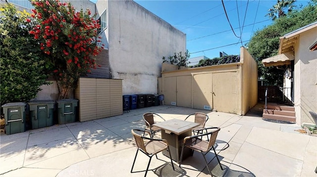 view of patio / terrace featuring outdoor dining space and an outbuilding