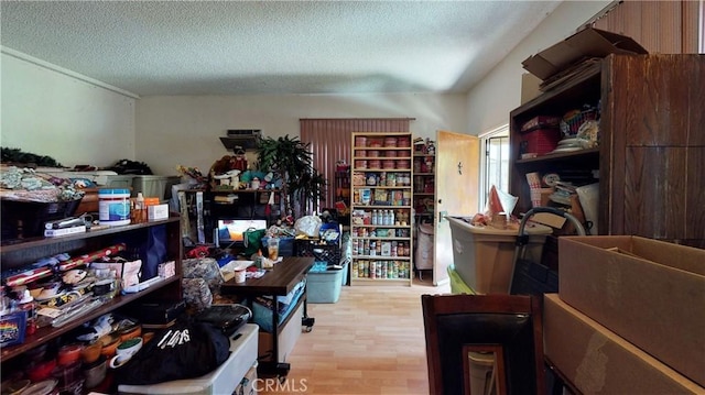 interior space with a textured ceiling and wood finished floors