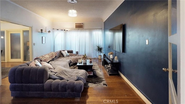 living area with a wall unit AC, baseboards, and wood finished floors