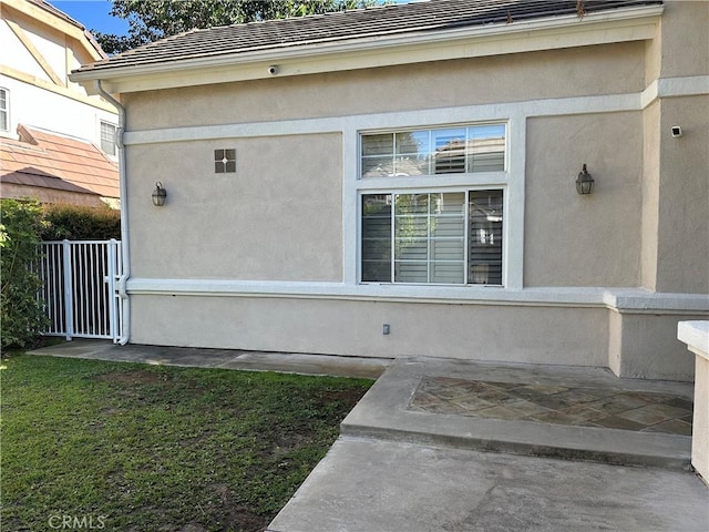 view of side of property featuring fence and stucco siding