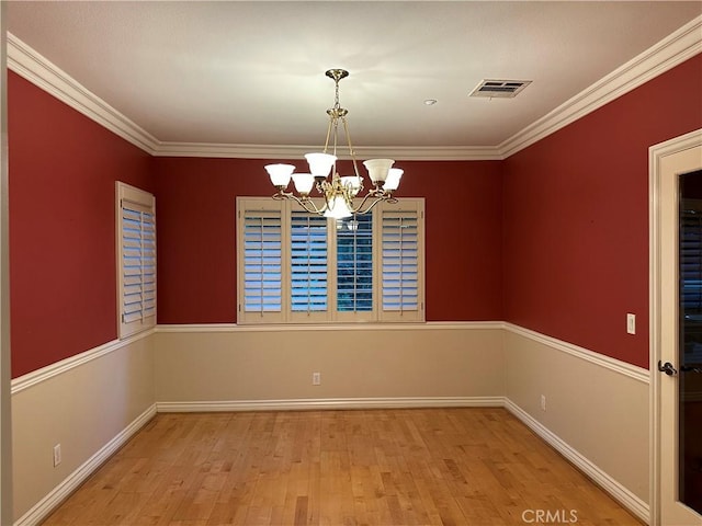 unfurnished dining area featuring ornamental molding, a chandelier, visible vents, and wood finished floors