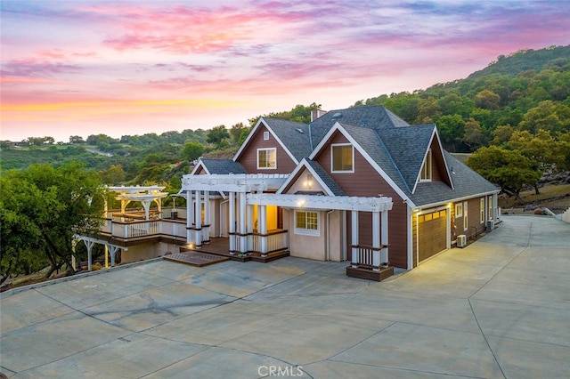 view of front of property featuring roof with shingles and a pergola