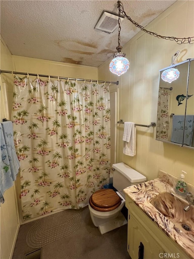 bathroom featuring visible vents, a shower with shower curtain, toilet, a textured ceiling, and vanity