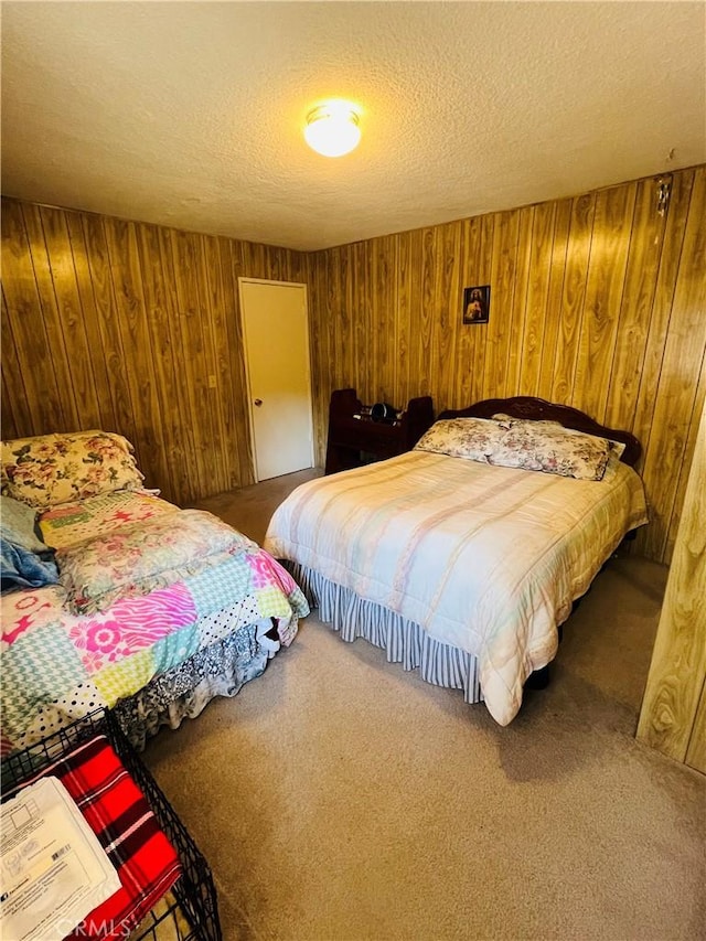 carpeted bedroom featuring wooden walls and a textured ceiling