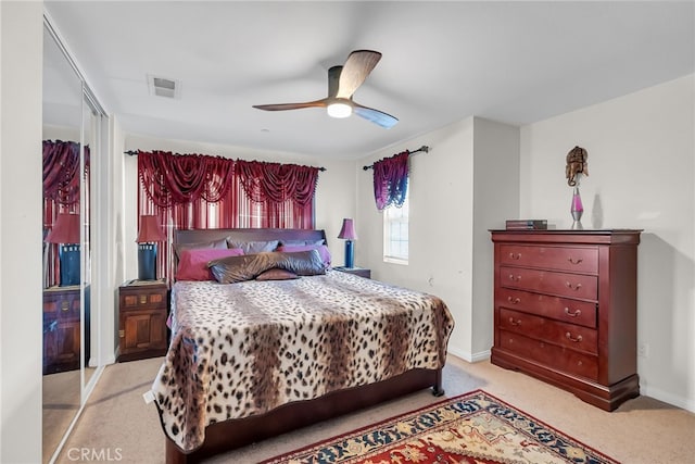 bedroom featuring ceiling fan, light carpet, visible vents, and baseboards