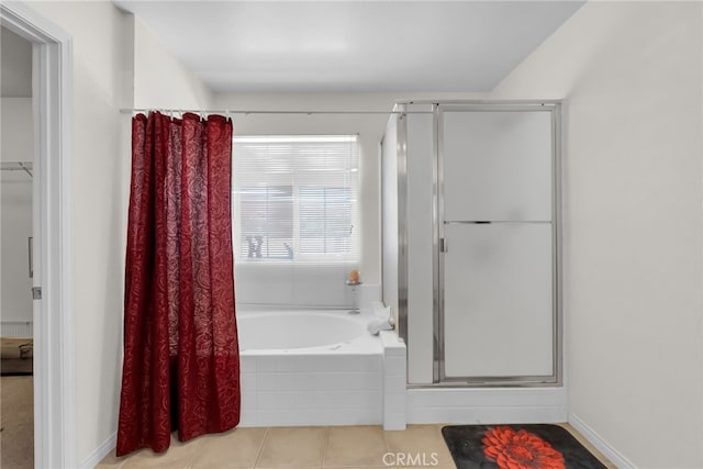 full bath featuring a stall shower, tile patterned flooring, a garden tub, and baseboards