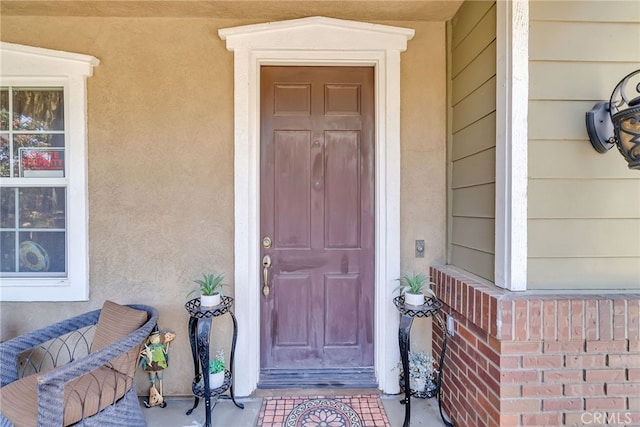 doorway to property featuring stucco siding