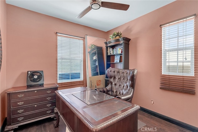 home office featuring dark wood-type flooring, a ceiling fan, and baseboards