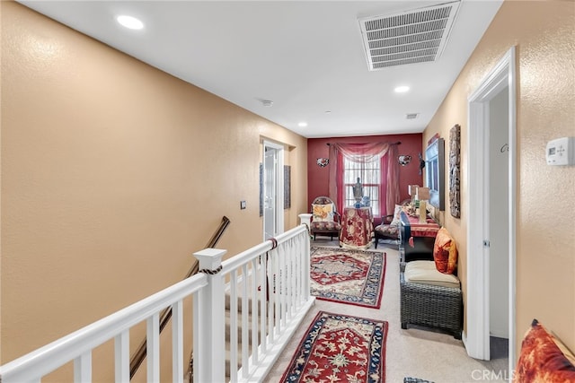 corridor with recessed lighting, an upstairs landing, visible vents, and light colored carpet