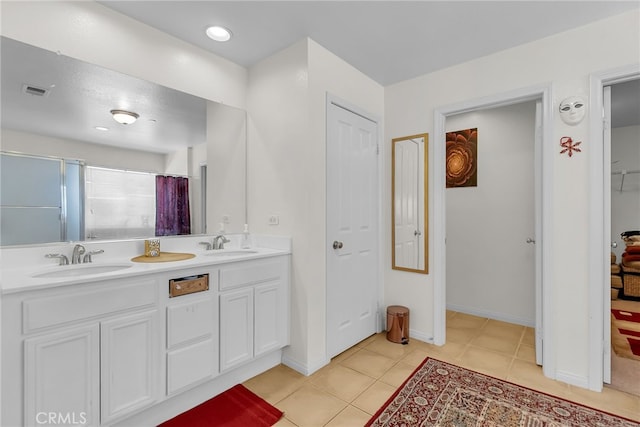 full bathroom featuring tile patterned flooring, a closet, a sink, and double vanity