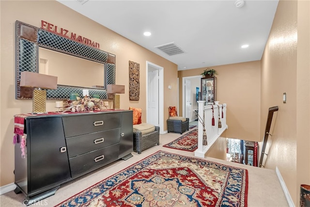 interior space featuring recessed lighting, baseboards, visible vents, and an upstairs landing