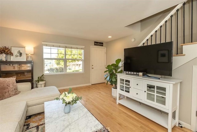 living area with light wood-style floors, recessed lighting, stairway, and baseboards