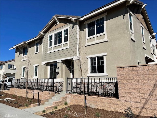 multi unit property featuring fence, board and batten siding, and stucco siding