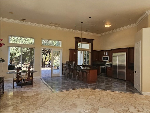 kitchen featuring dark countertops, a peninsula, ornamental molding, and stainless steel appliances