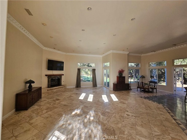 unfurnished living room with marble finish floor, baseboards, a fireplace with raised hearth, and ornamental molding