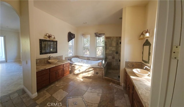 full bathroom featuring a garden tub, two vanities, a sink, a shower stall, and baseboards