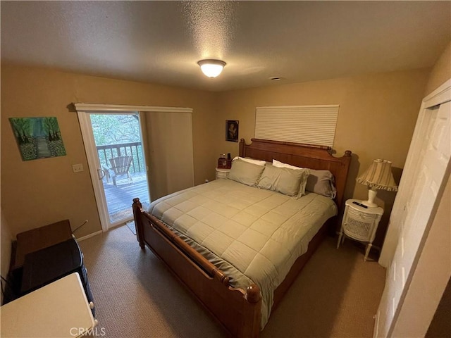 bedroom featuring access to exterior, baseboards, carpet floors, and a textured ceiling